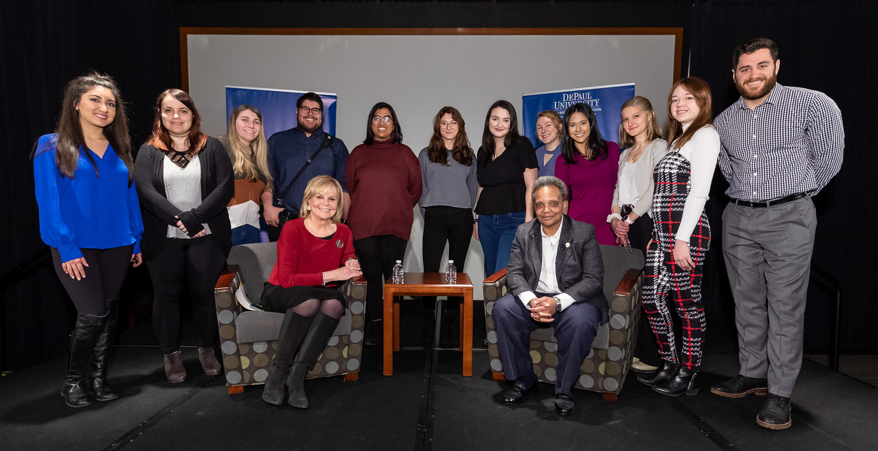 DePaul University students in Advanced Reporting pose for a photo with their instructor Carol Marin (seated left) and Chicago Mayor Lori Lightfoot. (DePaul University/Jeff Carrion)